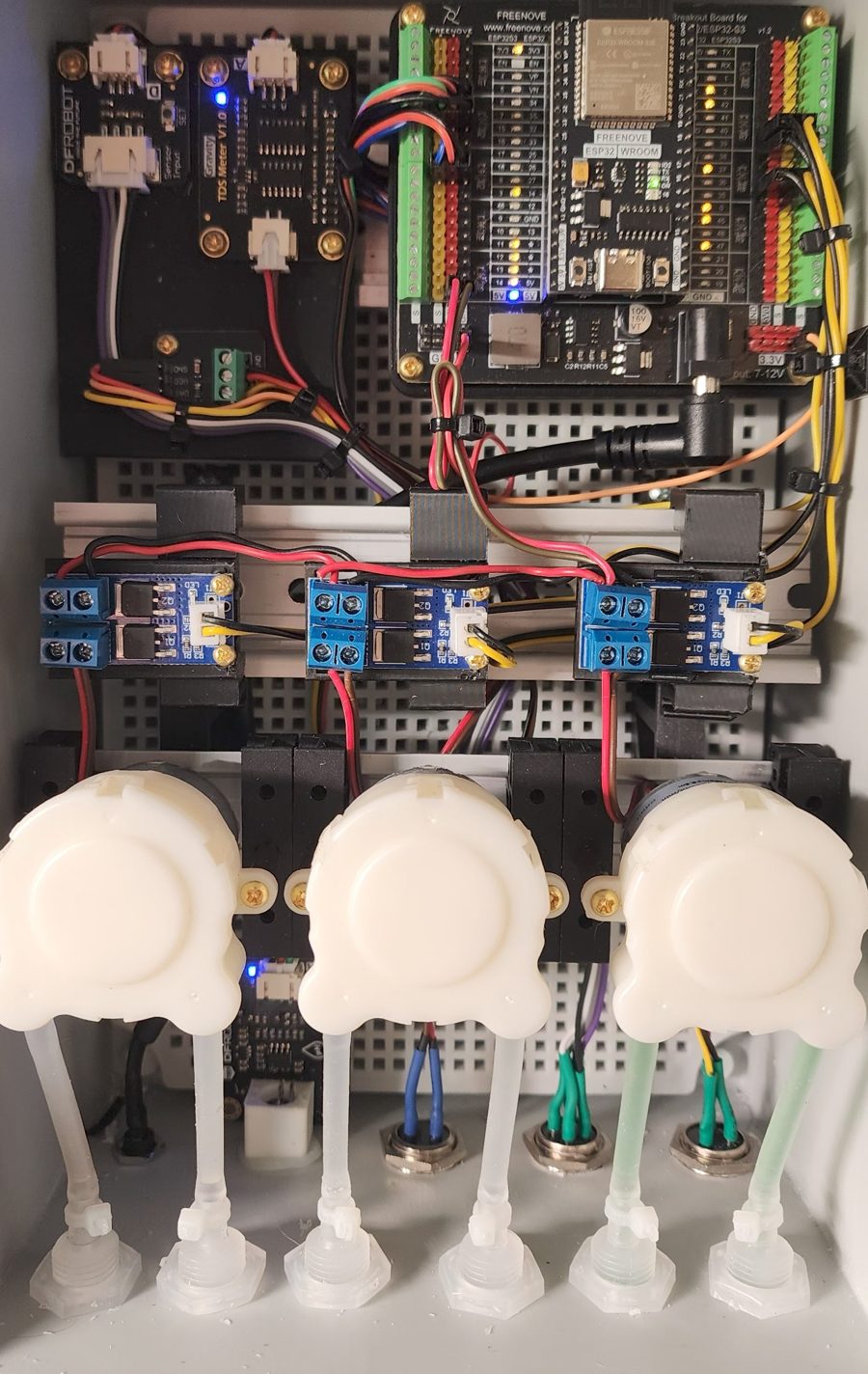 The ESP32, TDS meter, driver boards and three peristaltic pumps.